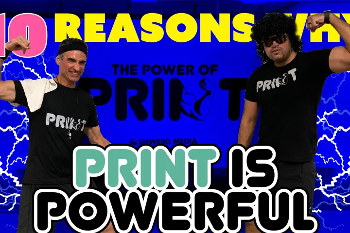 Gal Shweiki and Joey Dominguez flexing in front of The Power of Print banner.