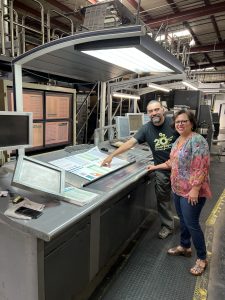 In a story about press check pressman and client standing next to a printing press