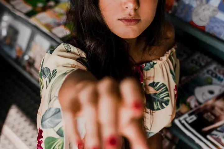 In a story about publishing a magazine a woman reaching out her had in front of a stack of magazines