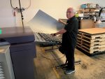 Man holding printing plate by CTP device
