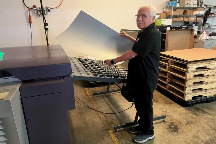 Man holding printing plate by CTP device
